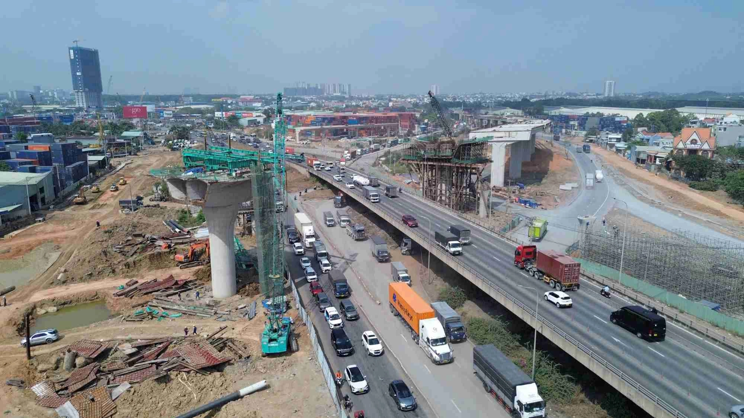 Nút giao Tân Vạn vừa thi công vừa phải tổ chức phân luồng trong điều kiện lưu lượng xe qua lại dày đặc mỗi ngày, đặc biệt là xe tải và container. Ảnh: Minh Quân